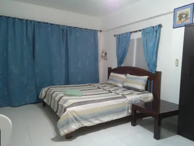 a bedroom with a bed with blue drapes at Rawai Condotel 3 in Rawai Beach