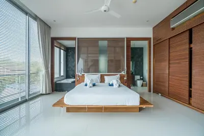 a bedroom with a bed and a large window at The Quarter by Lofty in Surin Beach