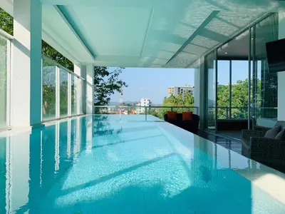 a large swimming pool in a building with windows at The Quarter by Lofty in Surin Beach