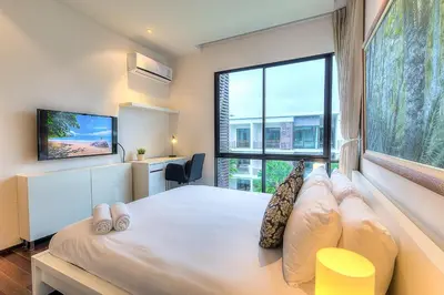 a bedroom with a large white bed and a large window at The Title Comfort Condotel in Rawai Beach