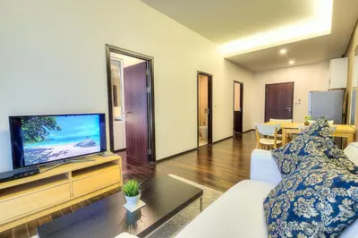 a living room with a couch and a flat screen tv at The Title Comfort Condotel in Rawai Beach