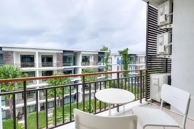 a balcony of a apartment with a table and chairs at The Title Comfort Condotel in Rawai Beach