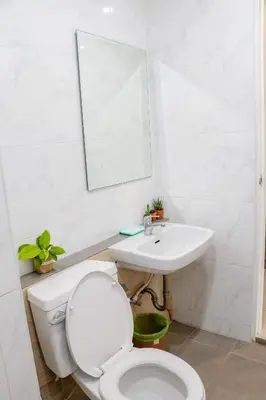 a white bathroom with a toilet and a sink at S2 Airport Residence in Nai Yang Beach