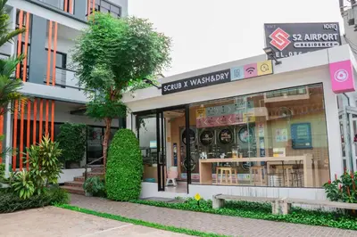 a store front of a building with a tree in front at S2 Airport Residence in Nai Yang Beach