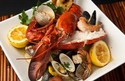 a plate of food with lobster and other seafood at The Retreat Ao nang Private Pool Villa in Ao Nang Beach