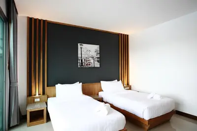a room with two beds with white sheets at The Malika Hotel - SHA Extra Plus in Phuket Town