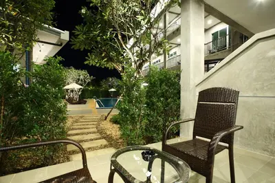 a chair and a table in front of a building at The Malika Hotel - SHA Extra Plus in Phuket Town