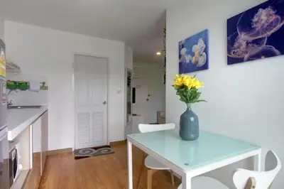 a kitchen with a table with a vase of flowers on it at Risa Plus in Kathu