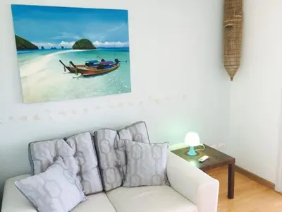 a living room with a couch and a picture of a boat in the water at Risa Plus in Kathu