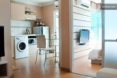 a kitchen with a table and a washing machine at Risa Plus in Kathu