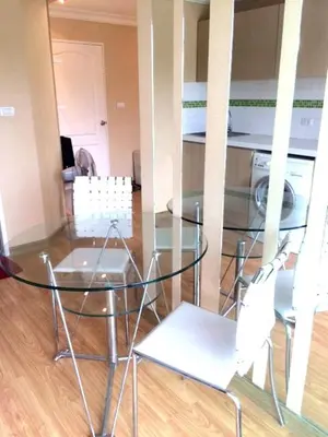a glass table and chairs in a room at Risa Plus in Kathu