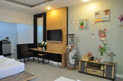 a living room with a tv on a wall at Eat n Sleep in Phuket Town