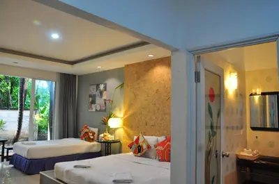 a hotel room with two beds and a window at Eat n Sleep in Phuket Town