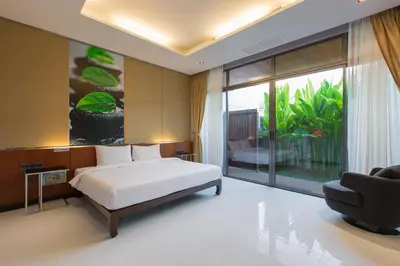 a bedroom with a bed and a large window at Aqua A1 in Rawai Beach