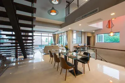a dining room and living room with a table and chairs at Aqua A1 in Rawai Beach