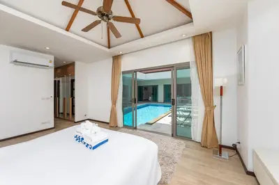 a bedroom with a bed and a swimming pool at Villa Bond 3BR Private Pool Near Naiharn Beach in Rawai Beach