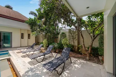 a patio with four chairs and a pool at Villa Bond 3BR Private Pool Near Naiharn Beach in Rawai Beach