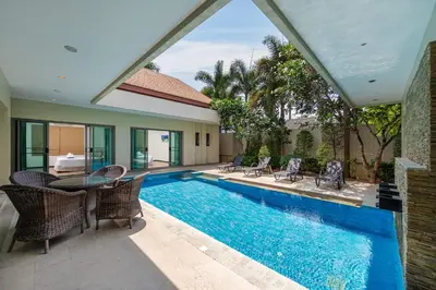a pool with chairs and a table next to a house at Villa Bond 3BR Private Pool Near Naiharn Beach in Rawai Beach