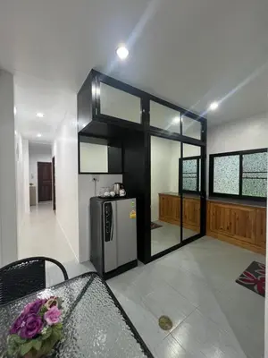 a kitchen with a refrigerator in the middle of a room at 65 Pradit in Nai Yang Beach