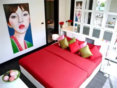 a red couch in a room with a painting of a woman at COCO Chalong 2 bedrooms New Villa in Chalong