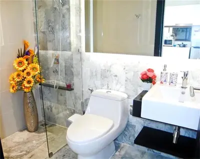 a bathroom with a toilet and a sink and a vase of flowers at COCO Chalong 2 bedrooms New Villa in Chalong