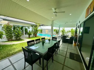 a patio with a table and chairs and a pool at Gabriel Villa by G Estate in Rawai Beach
