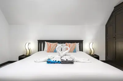 a bedroom with a bed with a towel on it at Champagne Villa by G Estate in Rawai Beach
