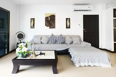 a bedroom with a bed and a coffee table at Champagne Villa by G Estate in Rawai Beach