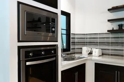 a kitchen with a microwave and a sink at Champagne Villa by G Estate in Rawai Beach