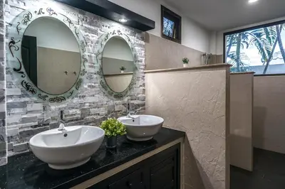 a bathroom with two sinks and two mirrors at Champagne Villa by G Estate in Rawai Beach