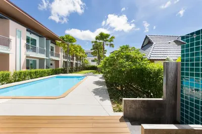 a swimming pool in front of a building at Parida Resort in Bang Tao Beach