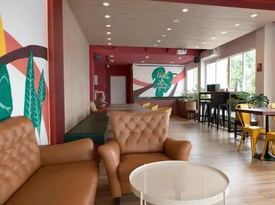a waiting room with chairs and tables and a screen at Parida Resort in Bang Tao Beach