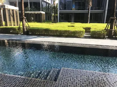 a pool of water in front of a building at Baan Mai Khao in Mai Khao Beach