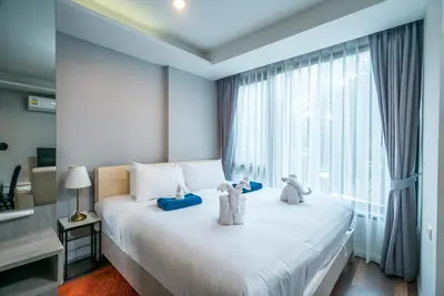 a bedroom with two teddy bears sitting on a bed at 6th Avenue Surin by Lofty in Surin Beach