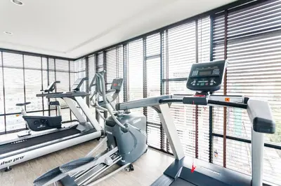 a gym with two treadmills and two ellipticals at 6th Avenue Surin by Lofty in Surin Beach