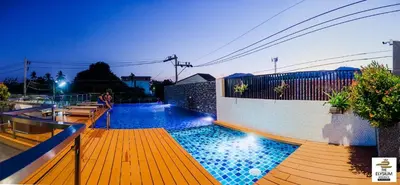 a swimming pool with a wooden deck and a fence at The Elysium Residence - SHA Extra Plus in Chalong