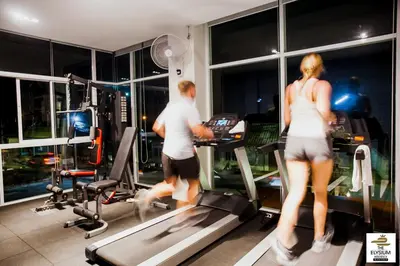a man and a woman on a treadmill in a gym at The Elysium Residence - SHA Extra Plus in Chalong