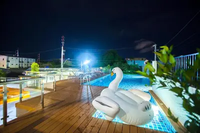 two white swans sitting on a deck at night at The Elysium Residence - SHA Extra Plus in Chalong
