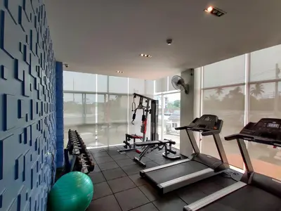 a gym with two tread machines in a room with windows at The Elysium Residence - SHA Extra Plus in Chalong