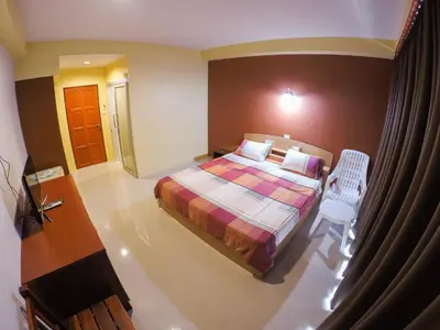 a bedroom with a bed and a chair in a room at Madam House in Karon Beach