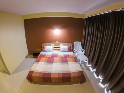 a bedroom with a bed and a window at Madam House in Karon Beach