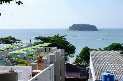 a view of the ocean from the balcony of a resort at Kata Beachwalk Hotel and Bungalows in Kata Beach