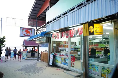 a group of shops on the side of a beach at Twin Palms Hostel Phi Phi in Phi Phi Don