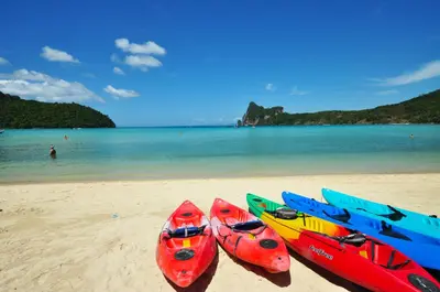 a group of three kayaks sitting on a beach at Twin Palms Hostel Phi Phi in Phi Phi Don
