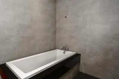 a white bath tub in a bathroom with tile walls at Emotion 2 Villa by G Estate in Rawai Beach