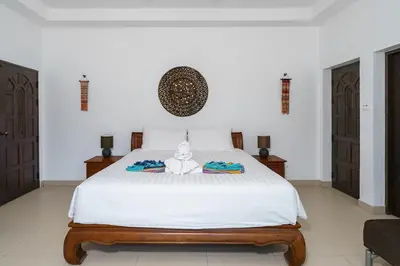a bedroom with a white bed with a stuffed animal on it at La Romanee Infinity by G Estate in Rawai Beach