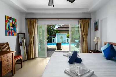 a bedroom with a bed with blue towels on it at Corton Villa by G Estate in Rawai Beach