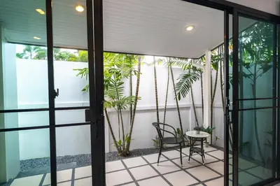 a patio with two chairs and a table at Clos Vougeot Villa by G Estate in Rawai Beach
