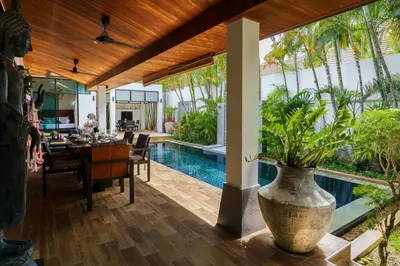a dining room with a pool and a vase with a plant at Emotion 1 Villa by G Estate in Rawai Beach
