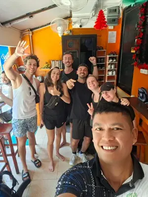a group of people posing for a picture at Voyagers Hostel in Phi Phi Don
